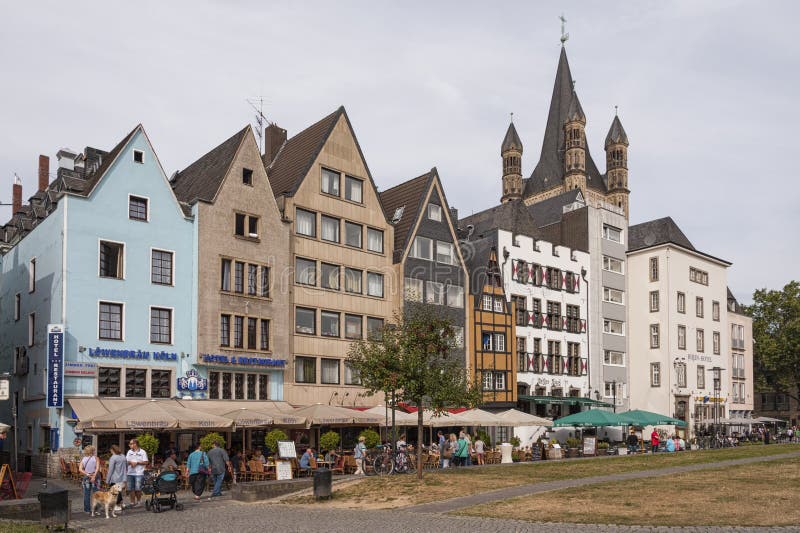 KEULEN, DUITSLAND - SEPTEMBER 11, 2016: Kleurrijke huizen in Beierse stijl en de Romaanse Katholieke kerk ` Brutosankt Martin ` stock afbeeldingen KEULEN, DUITSLAND - SEPTEMBER 11, 2016: Kleurrijke huizen in Beierse stijl en de Romaanse Katholieke kerk ` Brutosankt Martin ` stock afbeeldingen