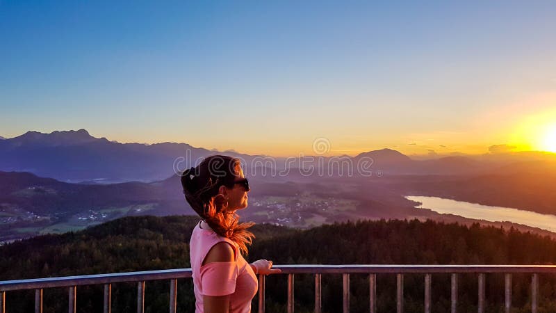 Keutschach - Een meisje geniet van de zonsondergang met het meerbeeld stock foto's Keutschach - Een meisje geniet van de zonsondergang met het meerbeeld stock foto's