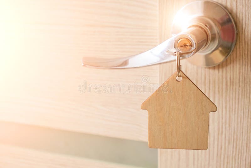 Key with Keychain in Form House in Door Lock.with Bright Sunlight Stock