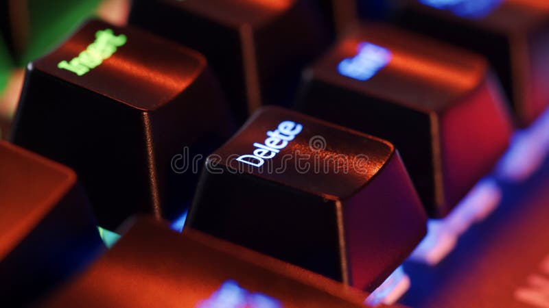 Keyboard key - Delete - macro shot. Modern gaming keyboard close-up with beautiful color backlight. Macro shooting of the rgb computer keyboard with backlight. Low angle view with soft focus
