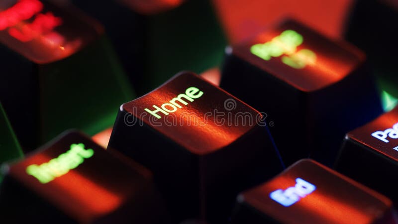 Keyboard key - Home - macro shot. Modern gaming keyboard close-up with beautiful color backlight. Macro shooting of the rgb computer keyboard with backlight. Low angle view with soft focus