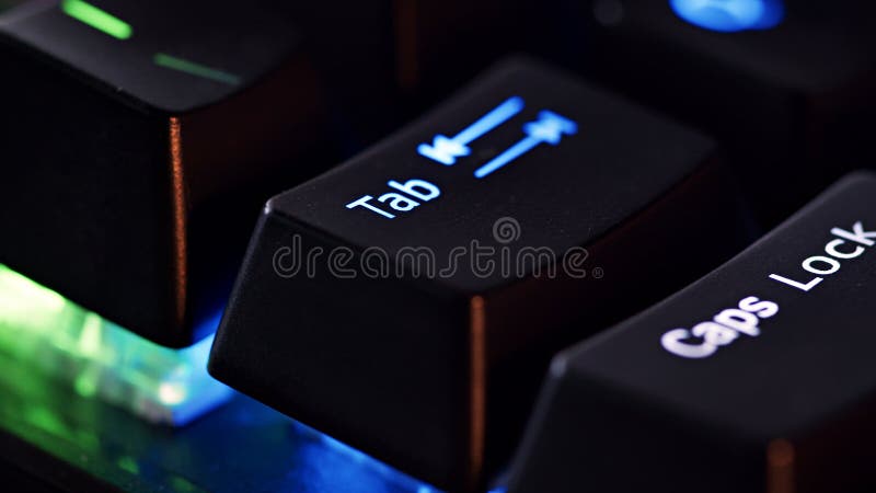 Keyboard key - Tab - macro shot. Modern gaming keyboard close-up with beautiful color backlight. Macro shooting of the rgb computer keyboard with backlight. Low angle view with soft focus