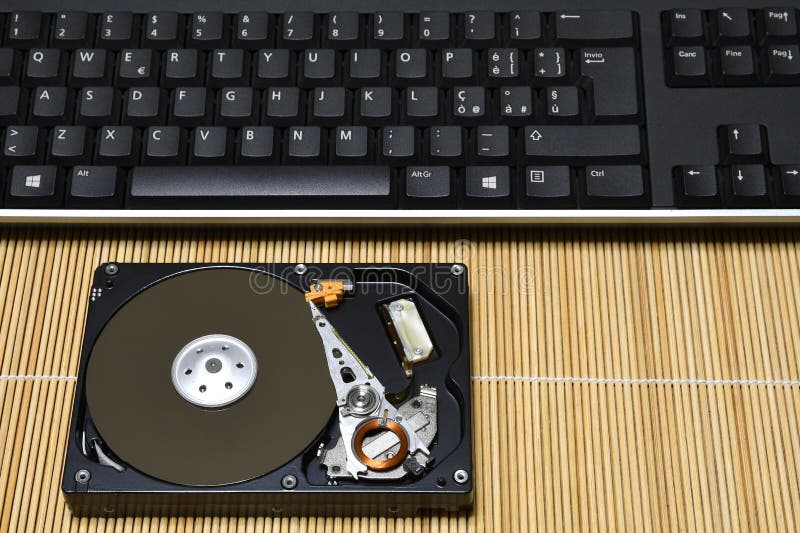 Keyboard and Open Hard Disk Drive on wood background stock photo