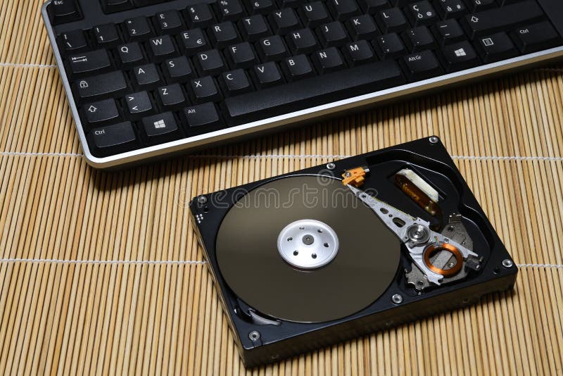 Keyboard and Open Hard Disk Drive on wood background stock photography