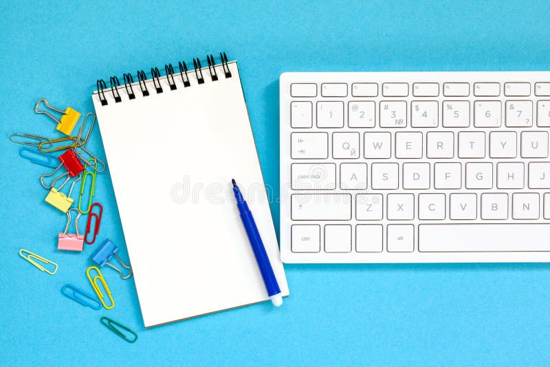 Keybord с пустой спиральной тетрадью, ручкой на голубой предпосылке Взгляд сверху с космосом экземпляра стоковые изображения Keybord с пустой спиральной тетрадью, ручкой на голубой предпосылке Взгляд сверху с космосом экземпляра стоковые изображения