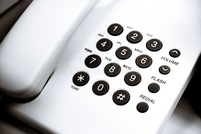 Keypad for telephonic communication or low angle view of a white office dial up landline. Selective focus