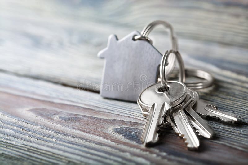 Keys to house with keychain on white wooden background stock photo Keys to house with keychain on white wooden background stock photo