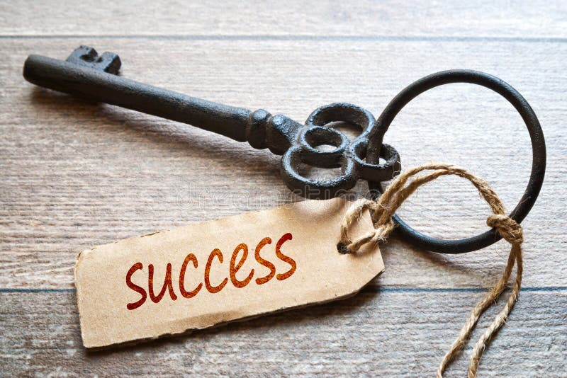 Keys to Success - Concept photo. Old key with paper label on wooden background - Success text. stock photography