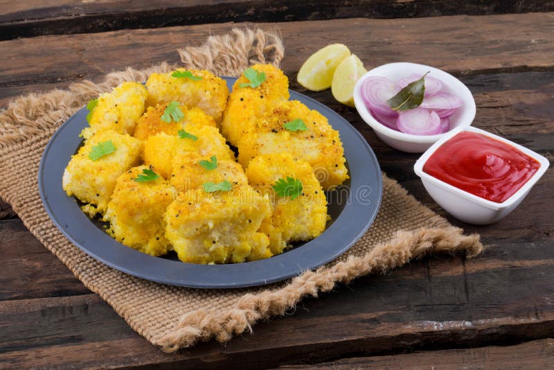 Khaman dhokla, cibo indiano per strada, su fondo di legno fotografia stock