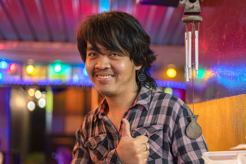Khaolak, Thailand, 5. Juni 2019: Thai-Mann, ein junger Mann in einem geplüschten Hemd glücklich und fröhlich er hält seinen Finge lizenzfreies stockfoto Khaolak, Thailand, 5. Juni 2019: Thai-Mann, ein junger Mann in einem geplüschten Hemd glücklich und fröhlich er hält seinen Finge lizenzfreies stockfoto