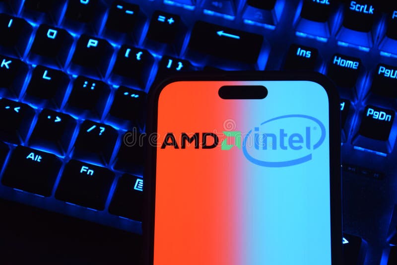 Phone with AMD and INTEL logo on computer background. stock photos
