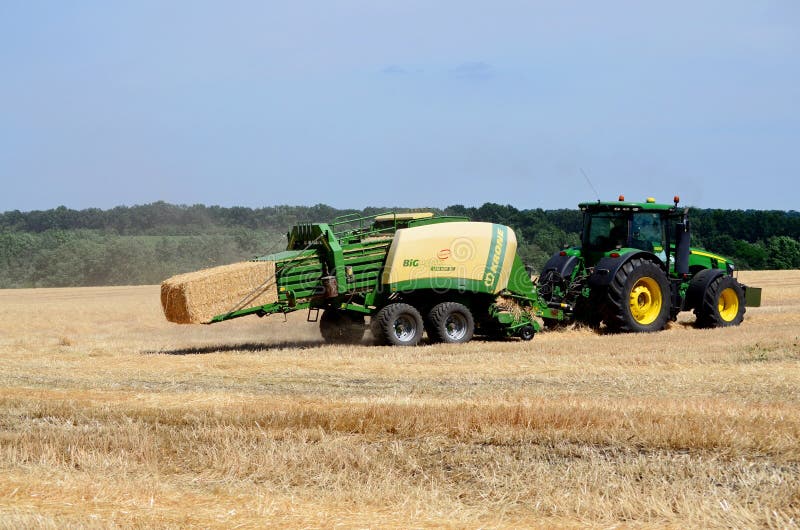 Kharkiv / Ukraine - June 27, 2019: Agricultural field of ripe sowing of rye, the harvester collects a rich crop of cereals