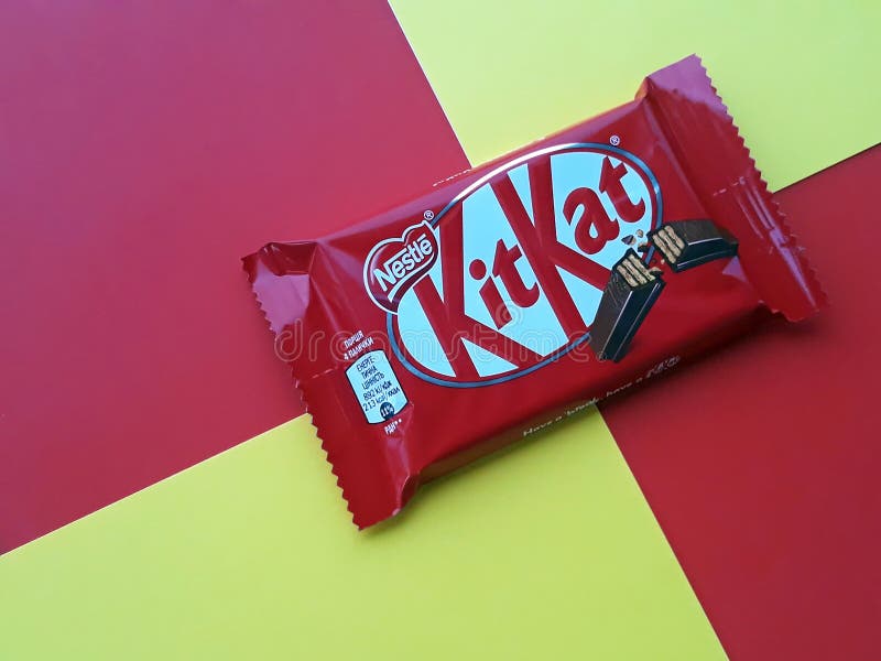 KHARKIV, UKRAINE - JANUARY 2, 2021 Kit Kat by Nestle chocolate covered wafer on bright color background. KHARKIV, UKRAINE - JANUARY 2, 2021 Kit Kat by Nestle chocolate covered wafer on bright color background