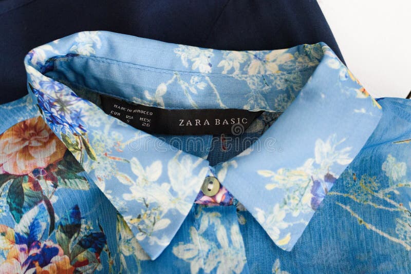 KHARKOV, UKRAINE - 27. APRIL 2019: Schwarze Aufkleber ZARA BASIC und Kragen der blauen Blumenbluse Kleidet Konzept sonderkommando lizenzfreie stockfotografie KHARKOV, UKRAINE - 27. APRIL 2019: Schwarze Aufkleber ZARA BASIC und Kragen der blauen Blumenbluse Kleidet Konzept sonderkommando lizenzfreie stockfotografie