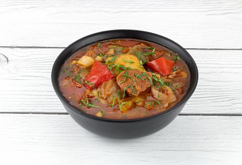 Khashlama Stew of Beef or Lamb Meat with Vegetables on a Black Plate