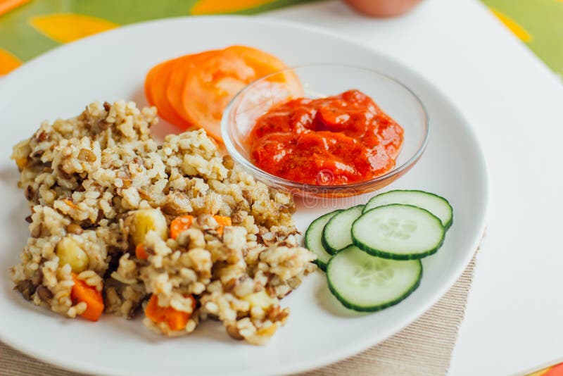 Khichdi con la salsa del tomate, del pepino y de tomate, visión superior imagen de archivo libre de regalías Khichdi con la salsa del tomate, del pepino y de tomate, visión superior imagen de archivo libre de regalías
