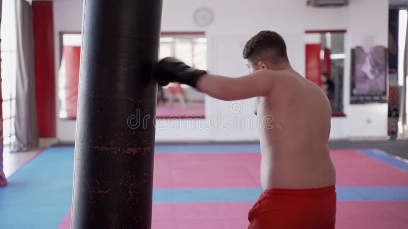 Kickboxer sovrappeso con il sacco pesante