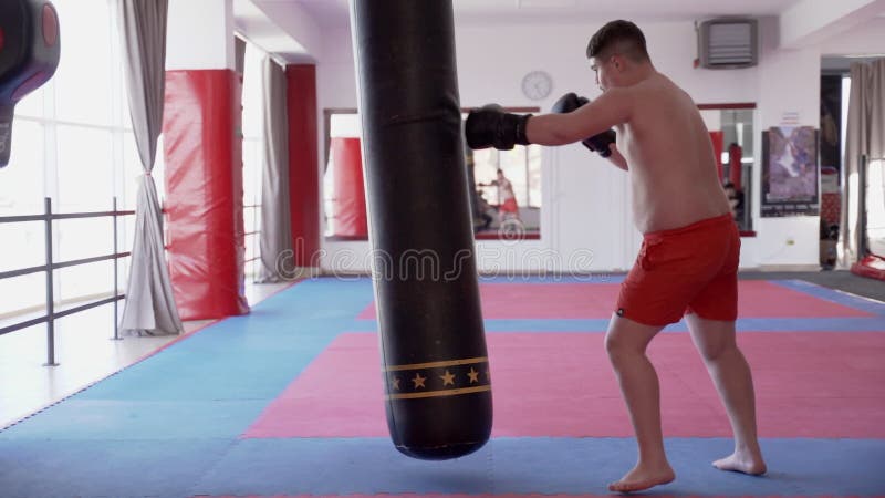 Kickboxer sovrappeso con il sacco pesante