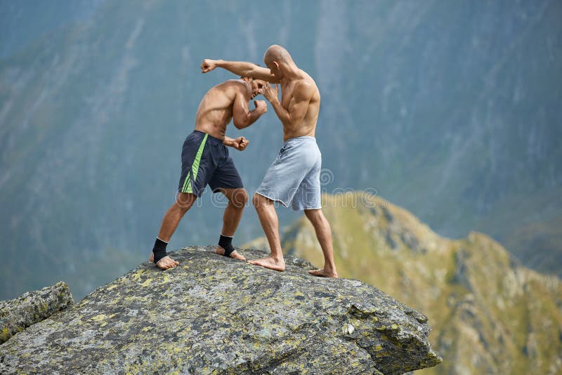 Kickboxers or muay thai fighters training on a mountain cliff stock image Kickboxers or muay thai fighters training on a mountain cliff stock image