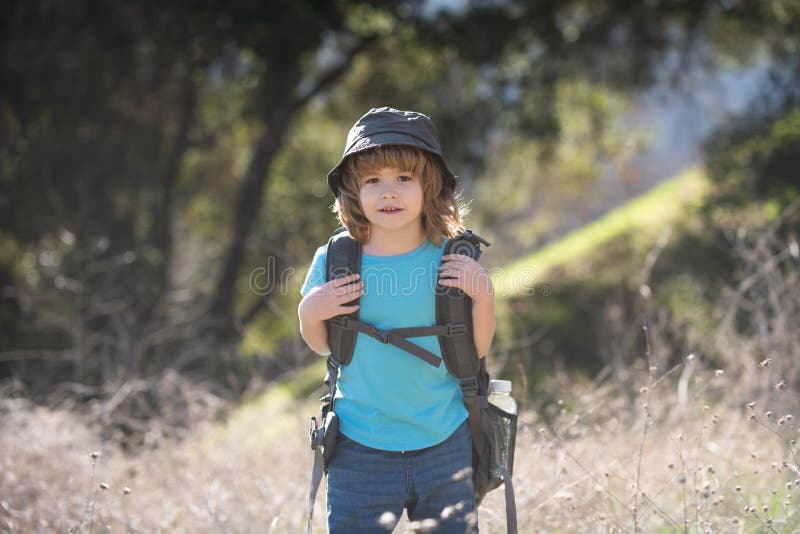 Kid with Backpack Hiking. Boy Tourist Goes on a Local Hike. Stock Photo