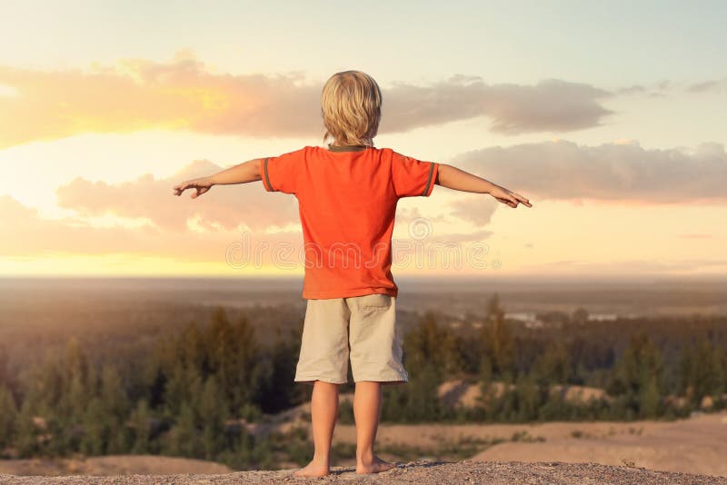 Kid Boy raised his hands up against the background sunset royalty free stock photography Kid Boy raised his hands up against the background sunset royalty free stock photography