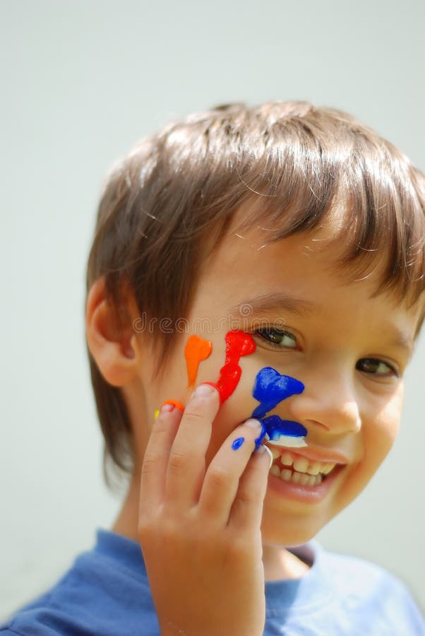 Kid with color on his fingers and face