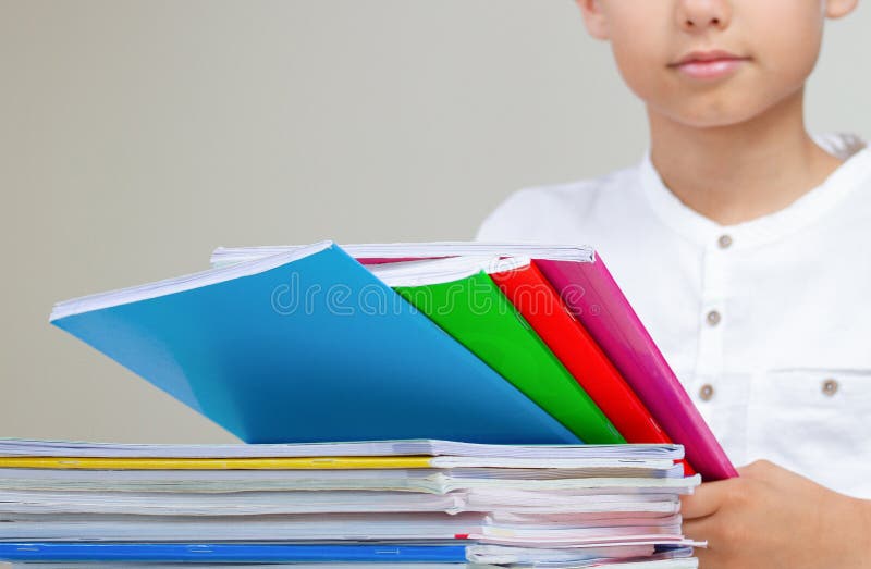 Kid with colorful books, notebooks and textbooks doing homework stock photography Kid with colorful books, notebooks and textbooks doing homework stock photography