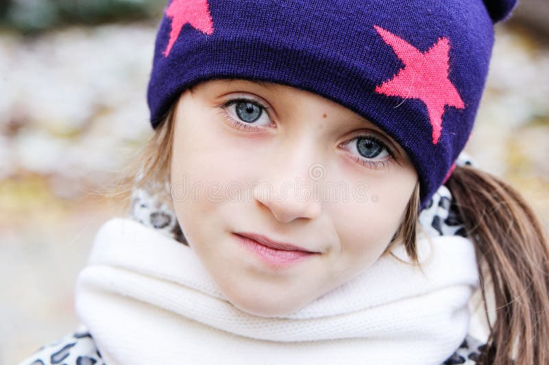 Kid girl has fun in garden with first snow