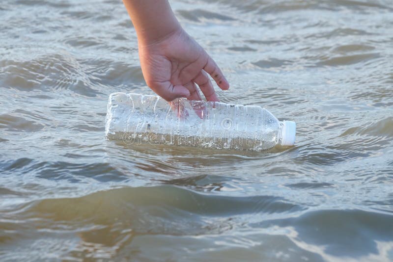 A Kid Hand Keeping a Plastic Bottle of Drinking Water from Sea Beach