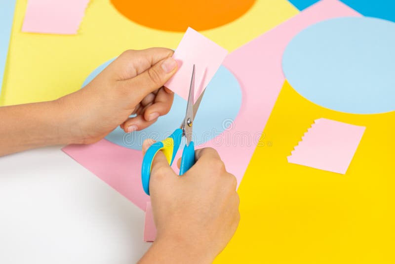 Kid,Hands,Cutting,Light,Blue,Colored,Paper,With,Scissors