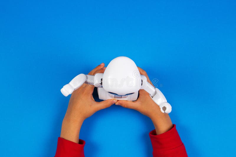 Kid hands with toy robot on blue background. stock images Kid hands with toy robot on blue background. stock images