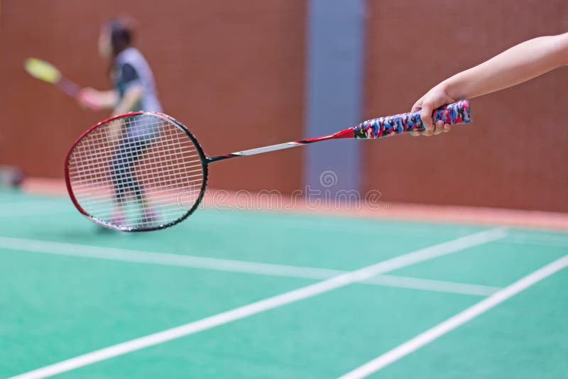 kid holding badminton racket in badminton court