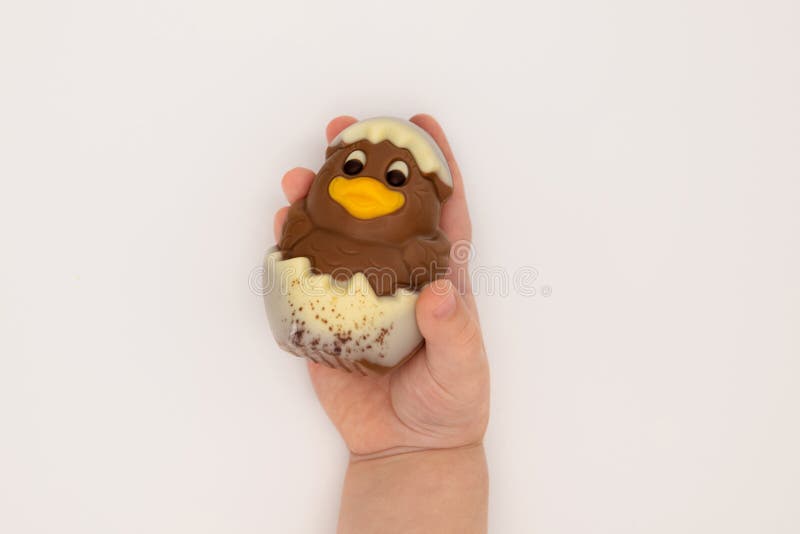 Kid holding figure of chocolate chicken hatched from an egg for Easter royalty free stock photos