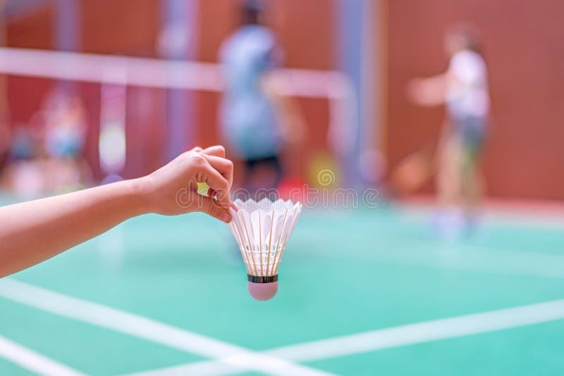 Kid holding shuttlecock in badminton court