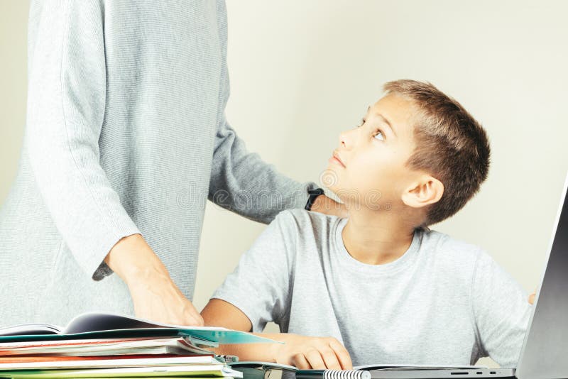 Kid learning online with laptop computer at home. Mother help him, explains task. Technology, remote education, distance. Learning, home studying royalty free stock image Kid learning online with laptop computer at home. Mother help him, explains task. Technology, remote education, distance. Learning, home studying royalty free stock image