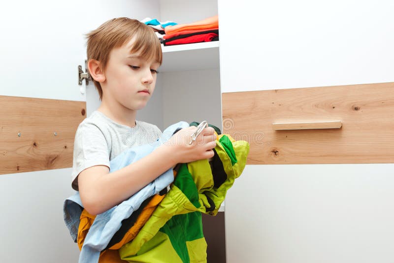 Kid Organizing Clothes in Wardrobe. Order in the Closet Stock Image ...