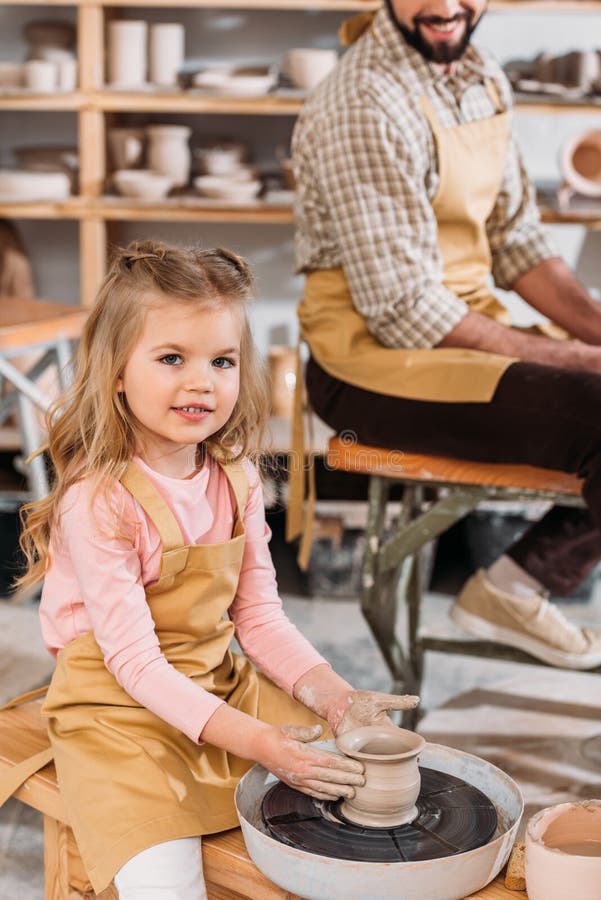 Kid Making Ceramic Pot on Pottery Wheel with Teacher Stock Image