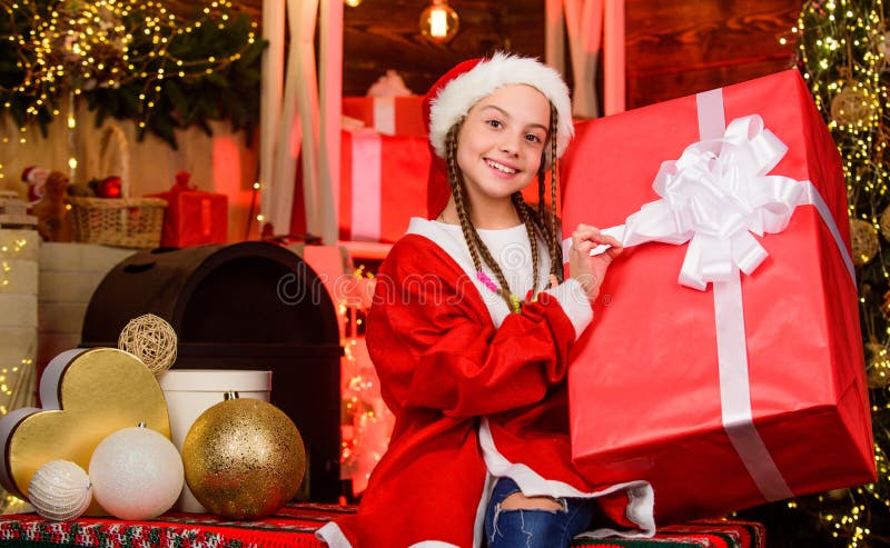 Kid with present box. winter shopping sale. magic gift box. Happy little smiling girl with christmas gift box. xmas mood. family holiday. kid in shopping mall. happy new year. child in red santa hat. Kid with present box. winter shopping sale. magic gift box. Happy little smiling girl with christmas gift box. xmas mood. family holiday. kid in shopping mall. happy new year. child in red santa hat.