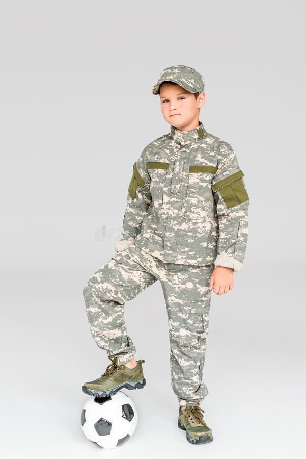 Kid in Military Uniform with Soccer Ball Looking at Camera Stock Photo