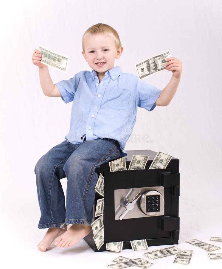 Kid sitting on the safe holding money. Kid sitting on the safe holding money