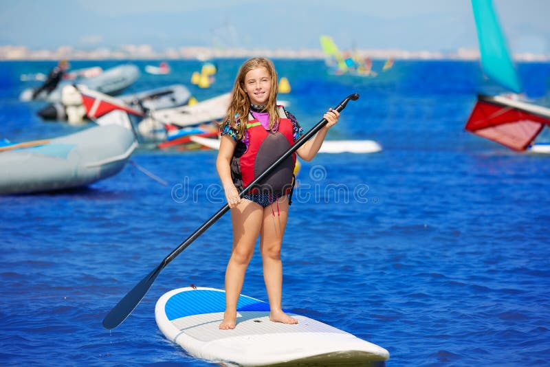 Kid Paddle Surf Surfer Girl with Row in the Beach Stock Photo Image