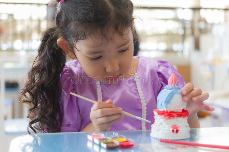 Kid painting color on the plaster statue