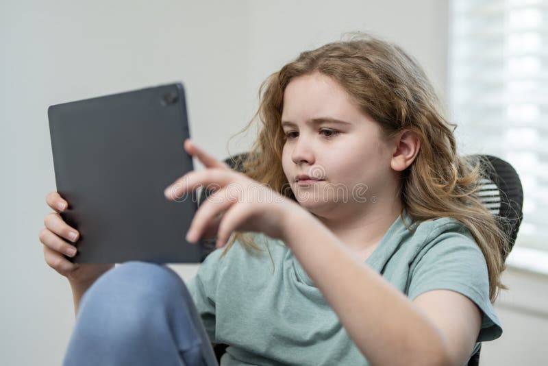 Kid play online game. Child using tablet for a game. Kid gamer holding a controller during an online game. Boy using a gaming royalty free stock photos