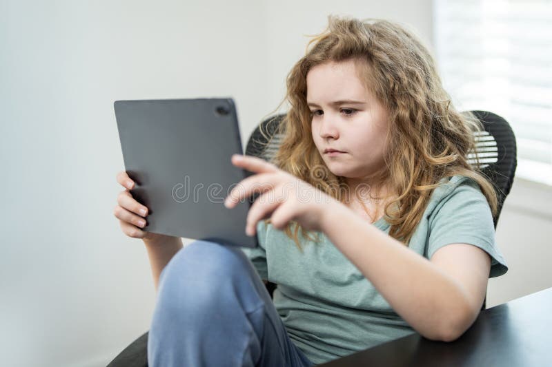Kid playing a video game in home room. Kid streaming video content while playing a digital game. stock photos