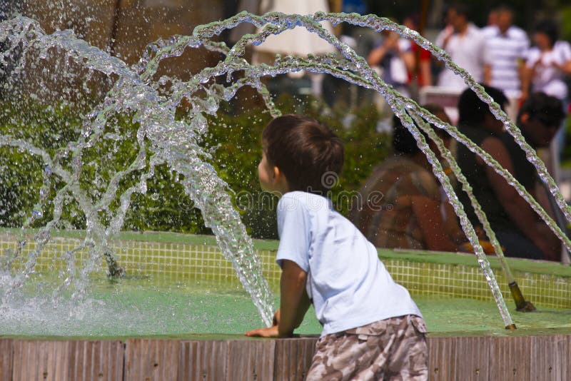 Kid playing with water fountain
