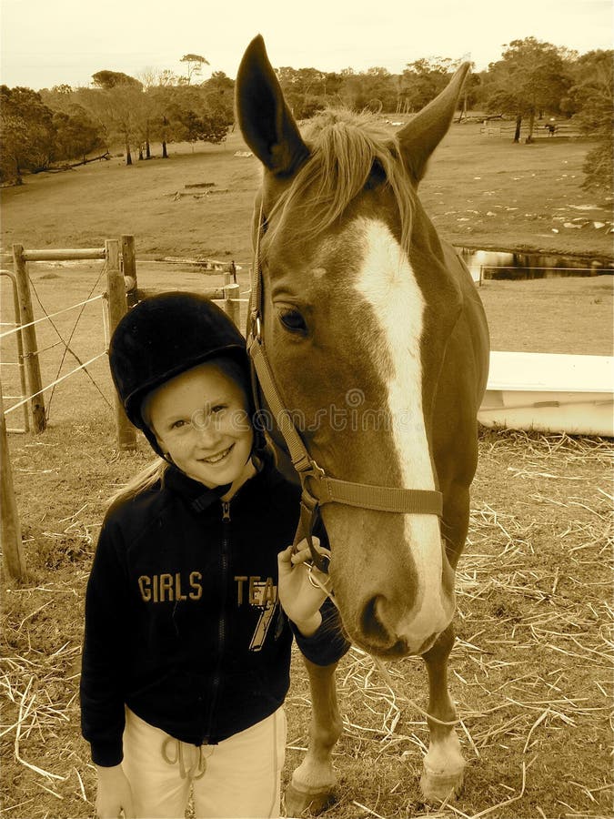 A sepia picture of a white caucasian girl child holding her horse pet. A sepia picture of a white caucasian girl child holding her horse pet