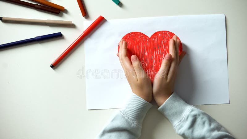 Kid putting hands on red heart picture, childhood and love, charity concept stock photo Kid putting hands on red heart picture, childhood and love, charity concept stock photo
