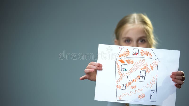 Kid showing house picture into camera, poor family needing home, social support, stock photo