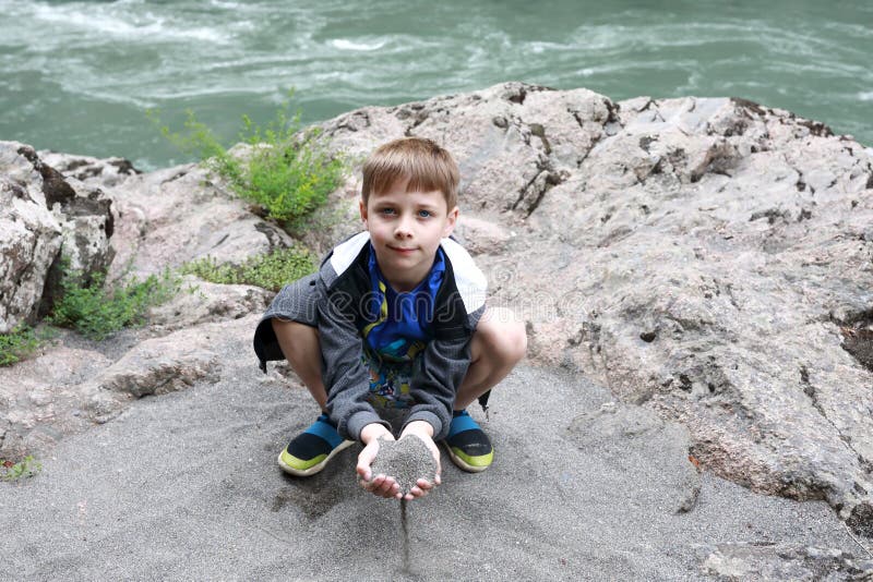 Kid sitting on bank of Belaya river in granite gorge stock images