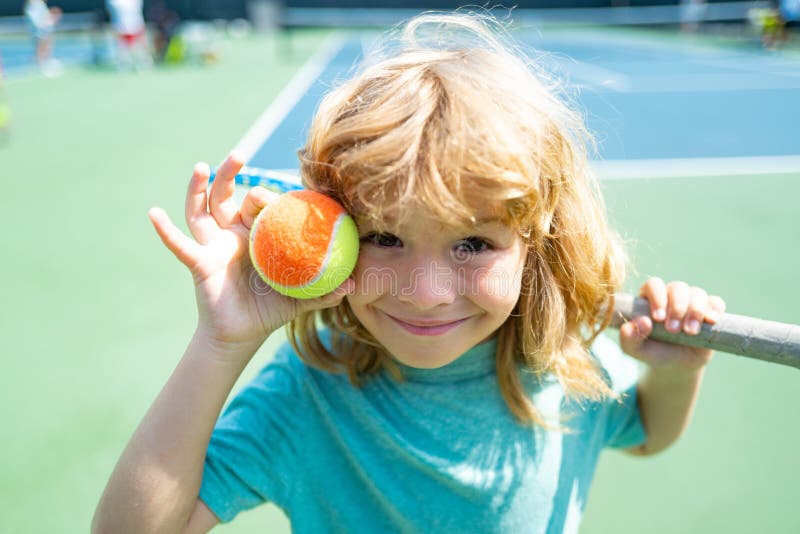 Kid Tennis Player on Tennis Court with Racket and Balls. Stock Photo